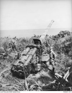 NEW IRELAND, 1945-10. JAPANESE HEAVY GUN WITH A JAPANESE OFFICER STANDING BY. (RNZAF OFFICIAL PHOTOGRAPH.)