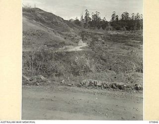 WASU - LAE ROAD, NEW GUINEA, 1944-02-20. A SECTION OF THE ROAD APPROXIMATELY 4 MILES FROM WAU ON THE SOUTH SIDE OF THE BULOLO RIVER. THE ROAD APPEARS IN THE FOREGROUND, AND CONTINUES BEYOND THE ..