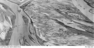 MARKHAM RIVER NEAR NADZAB, NEW GUINEA. 1943-09-05. AERIAL VIEW OF MEMBERS OF 7 PLATOON, 2/6TH FIELD COMPANY USING ROPES WITH TRIPODS AND PULLEYS (LIKE A FLYING FOX), TO MOVE RUBBER BOATS ACROSS THE ..