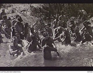 NADZAB AIRSTRIP, NEW GUINEA. 1943-09-19. TROOPS OF THE 2/5TH AUSTRALIAN FIELD COMPANY ATTACHED TO THE 25TH AUSTRALIAN INFANTRY BRIGADE ENJOY A WASH IN THE CREEK AFTER THEIR TWENTY FIVE MILE MARCH ..