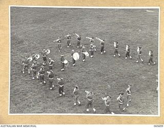 WONDECLA, QLD. 1944-04-05. THE BAND OF THE 2/2ND INFANTRY BATTALION PERFORMING THE STRAWBERRY BOX FORMATION AT THE FOOT OF THE JUDGES TOWER AT THE HERBERTON RACECOURSE