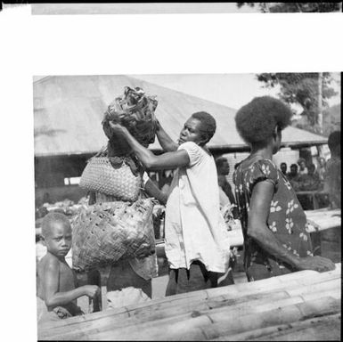 Woman assisting another to load produce, Boong, native market, Rabaul, New Guinea, ca. 1936, 2 / Sarah Chinnery