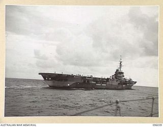 AT SEA OFF RABAUL, NEW BRITAIN. 1945-09-06. THE AIRCRAFT CARRIER HMS GLORY, SEEN FROM THE BOW OF THE SLOOP HMS HART DURING THE SURRENDER CEREMONY. THE SURRENDER OF ALL JAPANESE FORCES IN NEW ..