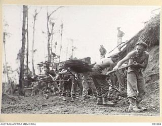 BERRY'S HILL, CENTRAL BOUGAINVILLE, 1945-06-27. TROOPS OF 7 INFANTRY BATTALION WORKING WITH SHOVELS ON ROAD CONSTRUCTION ON BERRY'S HILL. THE ROAD WILL ENABLE SUPPLIES TO BE EXPEDITED TO FORWARD ..