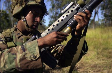 Corporal Jason Desautels, USMC, from India Company, 3rd Battalion, 3rd Marines weapon platoon, Kaneohe Bay, Hawaii loads his M2O3 Grenade Launcher attached to his Colt M16A2 5.56mm Assault Rifle during Exercise TANDEM THRUST. India Company is conducting a live fire range exercise consisting of firing AT-4 Rocket Launchers, Shoulder Mounted Anti Armor Weapons, and M-2O3 40mm Grenade Launchers at the Shoalwater Bay Training Area. TANDEM THRUST is a biennial combined United States and Australian military training exercise, held in the vicinity of Shoalwater Bay Training Area in Queensland, Australia. More than 27,000 Soldiers, Sailors, Airmen and Marines are participating, with Canadian...