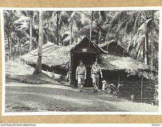 MILNE BAY, NEW GUINEA. 1943-06-26. QX43433 SIGNALMAN L.J. CALLEN (LEFT) AND Q46579 PRIVATE H.J. SMITH MARCHING OUT OF THE SIGNAL OFFICE, HEADQUARTERS, 5TH AUSTRALIAN DIVISION