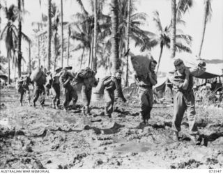 ALEXISHAFEN, NEW GUINEA. 1944-05-12. POSTAL ORDERLIES FROM FIELD POST OFFICE NO.156 CARRYING MAIL FROM THE WHARF TO THE POST OFFICE AT HEADQUARTERS 8TH INFANTRY BRIGADE. IDENTIFIED PERSONNEL ARE:- ..