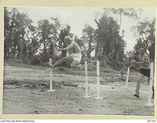 BOUGAINVILLE. 1945-04-25. PRIVATE E. GOLDEN, 26 INFANTRY BATTALION (1), AND SERGEANT L.J. MCKENZIE, 8 INFANTRY BATTALION (2), TRYING OUT LOW HURDLES AT THE 2/3 CONVALESCENT DEPOT TABLOID SPORTS ..