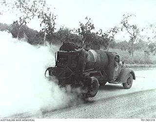 WARDS STRIP, PORT MORESBY, NEW GUINEA, 1943-03. A MEMBER OF THE RAAF DRIVES A BITUMEN SPRAYER OVER GRAVEL FOR A NEW TAXIWAY. WARDS AERODROME WAS WORKED ON BY BOTH NO. 2 AND NO. 5 MOBILE WORKS ..