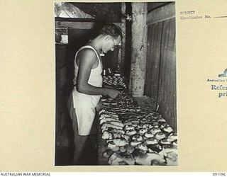 JACQUINOT BAY, NEW BRITAIN. 1945-04-26. PRIVATE A.J. COLEMAN, CREAMS SOME CAKES AT A SCHOOL OF COOKING CONDUCTED BY WARRANT OFFICER II GIBBES AT 4 FIELD AMBULANCE