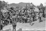 Bride price ritual: decorated men from the groom's group dance, chant and drum in bride's village