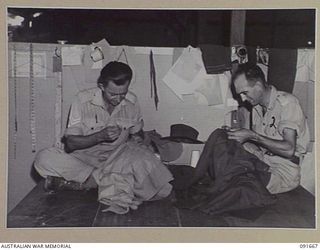 TOROKINA, BOUGAINVILLE. 1945-05-07. SERGEANT B.F. ERNST (1), AND SERGEANT A.M. BOWMAN (2), TAILORS AT 4 SECTION OFFICERS' SHOP, SEWING UNIFORMS BY HAND