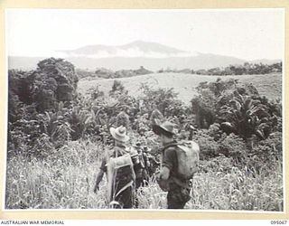 KIARIVU, NEW GUINEA, 1945-08-06. MEMBERS OF 2/7 INFANTRY BATTALION ON A SIX DAY PATROL INTO ENEMY TERRITORY NEARING MOUNT TURU, 4,000 FEET HIGH. THE MOUNTAIN IS A DOMINATING FEATURE OF THIS PORTION ..