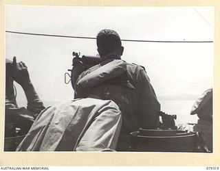 BUT AREA, NEW GUINEA. 1945-02-26. THE FIRST LIEUTENANT OF THE RAN VESSEL HMAS SWAN TAKING A BEARING OVER THE PELORUS DURING A RAN BOMBARDMENT OF THE JAPANESE POSITIONS IN THE BUT- KUAK AREA BETWEEN ..
