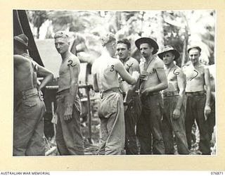 JACQUINOT BAY, NEW BRITAIN. 1944-11-10. TROOPS OF HEADQUARTERS, 5TH DIVISION LINING UP FOR THEIR SECOND CHOLERA NEEDLE AT THE MALMAL MISSION REGIMENTAL AID POST. IDENTIFIED PERSONNEL ARE: NX13543 ..