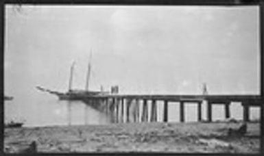 People standing on dock, near boat