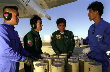 Aviation Ordnancemen of the Japan Maritime Self Defense Force P-3C Orion Detachment 33 discuss procedures for loading sonobouys on the aircraft for an anti-submarine warfare mission during the exercise RIMPAC 98