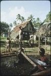 House-building: men plant vertical post with notched top, boy holds hand saw