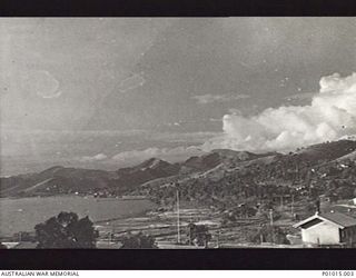 SALAMAUA, NEW GUINEA, 1944. VIEW OF DWELLINGS, THE BAY WITH MOUNTAINS IN THE BACKGROUND