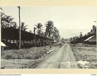 LAE, NEW GUINEA. 1944-03-29. POWRIE ROAD PASSING THROUGH THE MAIN BULK STORES AT THE 39TH SUPPLY DEPOT COMPANY. THE ROAD COMMEMORATES THE NAME OF A MEMBER OF THE UNIT WHO DIED ON SERVICE