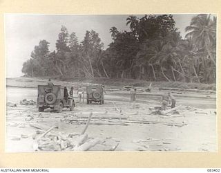 BABIANG AREA, NEW GUINEA, 1944-11-18. TROOPS OF 2/6 CAVALRY (COMMANDO) REGIMENT ABOUT TO BOIL THE BILLY DURING A MID DAY HALT AT A RIVER CROSSING. THREE JEEPS ARE BEING USED TO DETERMINE THE ..