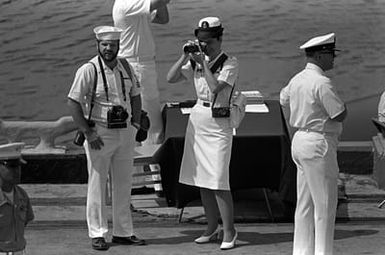 A Navy photographer takes pictures of the ceremony marking the assumption of command of the U.S. Pacific Fleet by Adm. Sylvester R. Foley Jr