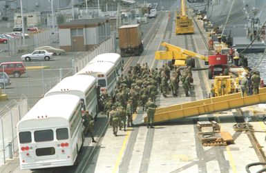 Troops of the 25th Infantry Division assemble on the pier as they prepare to board the amphibious assault ship USS BELLEAU WOOD (LHA-3) for transport to Kauai as part of Task Force Garden Isle, a joint military disaster relief effort being conducted in the aftermath of Hurricane Iniki