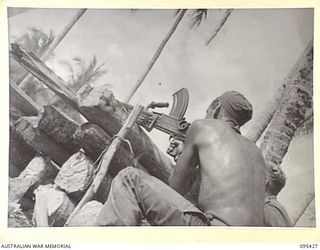 KIARIVU, NEW GUINEA, 1945-08-14. PRIVATE A.D. BENTLEY, 2/7 INFANTRY BATTALION FIRING HIS BREN GUN FROM A WEAPON PIT AT A JAPANESE HELD POSITION