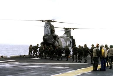 Marines on the flight deck of the amphibious assault ship USS SAIPAN (LHA-2) board a CH-46E Sea Knight helicopter from Marine Medium Helicopter Squadron 261 (HMM-261) for transportation to Monrovia, Liberia, to evacuate dependents and non-essential U.S. Embassy staff from the midst of fighting between Liberian government forces and rebel factions