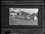 Group of approximately 100 people in lines in field.