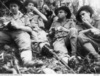 SHAGGY RIDGE, NEW GUINEA. 1943-12-27. TROOPS OF HEADQUARTERS COMPANY 2/16TH AUSTRALIAN INFANTRY BATTALION, 21ST AUSTRALIAN INFANTRY BRIGADE PAUSE FOR A REST ON THE STEEP SLOPES OF THE "PIMPLE". ..