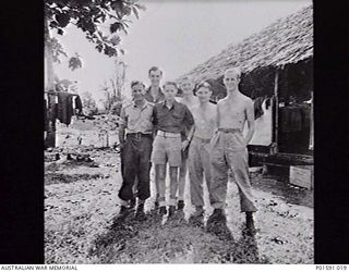 LAE, NEW GUINEA. C.1945. MEMBERS OF THE FAR EASTERN LIAISON OFFICE OUTSIDE THEIR HEADQUARTERS. SERGEANT N. (NAT) F. DANIELL IS AT THE REAR