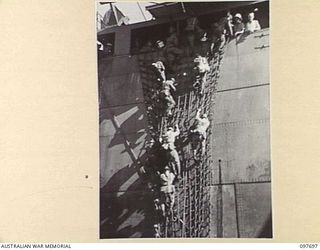 TOROKINA, BOUGAINVILLE. 1945-09-21. JAPANESE TROOPS FROM NAURU ISLAND CLAMBERING DOWN THE SIDE OF THE SS RIVER BURDEKIN INTO BARGES WHICH WILL TAKE THEM ASHORE AT TOROKINA FROM WHENCE THEY WILL ..