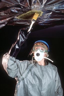 SRA Julia Reichenberger, a member of the 43rd Bombardment Wing Corrosion Control Branch, applies paint remover before grinding and repainting a B-52G Stratofortress aircraft wing tip