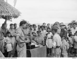 RABAUL, NEW BRITAIN, 1945-12-04. A YOUNG CHINESE GIRL POINTING OUT A JAPANESE AT AN IDENTIFICATION PARADE OF SUSPECTED JAPANESE WAR CRIMINALS HELD AT THE HEADQUARTERS OF THE CHINESE CIVILIAN CAMP.