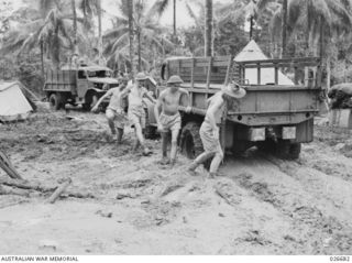 MILNE BAY, PAPUA. 1942-10. A TRUCK OF THE AUSTRALIAN FORCES IN DIFFICULTIES IN THE MUD IN A CAMPING AREA IN THE MILNE BAY AREA
