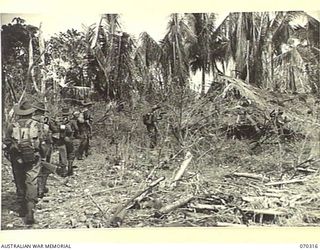 MALALAMAI, YAGOMAI, NEW GUINEA, 1944-02-09. TROOPS OF THE 30TH INFANTRY BATTALION ON THE ALERT AS THEY MOVE THROUGH A NATIVE VILLAGE WHICH WAS MORTARED THE PREVIOUS DAY. IDENTIFIED PERSONNEL ARE: ..