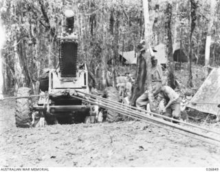 25-POUNDER GUNS OF B TROOP, 14TH FIELD REGIMENT, ROYAL AUSTRALIAN ARTILLERY, BEING PULLED THROUGH DENSE JUNGLE IN THE VICINITY OF UBERI ON THE KOKODA TRAIL. MEMBERS OF THE REGIMENT ARE BEING ..
