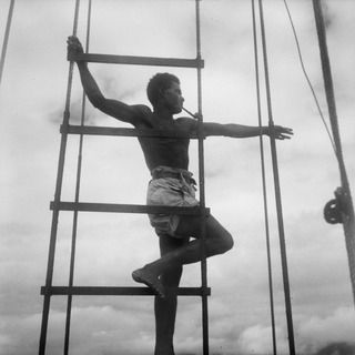 LAE, NEW GUINEA. 1944-06-14/02. A NEW GUINEA NATIVE PILOT GUIDING A SHIP OF THE 12TH WATER TRANSPORT OPERATING COMPANY, THROUGH SHALLOW WATERS ALONG THE COAST