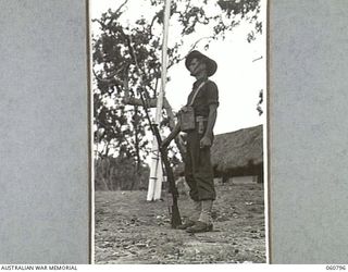 POM POM VALLEY, NEW GUINEA. 1943-11-27. SX16387 PRIVATE H. R. SCOTT, SENTRY, ON DUTY OUTSIDE HEADQUARTERS, 18TH AUSTRALIAN INFANTRY BRIGADE