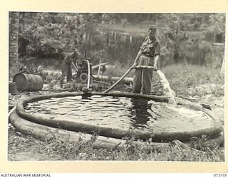 ALEXISHAFEN, NEW GUINEA. 1944-05-10. NX175008 SAPPER M.C. MACKAY (1), AND NX123676 SAPPER J.L. MCGRATH (2), MEMBERS OF THE 8TH FIELD COMPANY, 8TH INFANTRY BRIGADE WORKING A WATER POINT TO SUPPLY ..