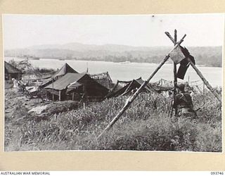 WEWAK AREA, NEW GUINEA, 1945-07-03. SERGEANT R.E. KINNANE, 2/6 SURVEY BATTERY, ROYAL AUSTRALIAN ARTILLERY, FIXING 25-POUNDER POSITION. EACH AUSTRALIAN DIVISION IS NOW PROVIDED WITH AN ARTILLERY ..