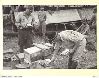 MUSCHU ISLAND, NEW GUINEA. 1945-09-11. JAPANESE NAVAL AND ARMY OFFICERS CHECKING STORES SUPPLIED BY HEADQUARTERS 6 DIVISION. THE ISLAND WAS SURRENDERED BY REAR-ADMIRAL SATO TO MAJOR GENERAL ..