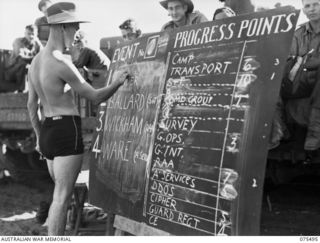 LAE, NEW GUINEA. 1944-08-27. NX147889 CAPTAIN H GILCHRIST, EDUCATION OFFICER, HEADQUARTERS, NEW GUINEA FORCE KEEPING THE UNIT SCOREBOARD UP TO DATE DURING THE SURF CARNIVAL ORGANISED BY ..