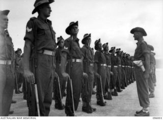 WEWAK AIRSTRIP, NEW GUINEA. 1945-09-03. TROOPS OF 2/11 INFANTRY BATTALION RIGHT DRESS IN PREPARATION FOR A REVIEW BY BRIGADIER J.E.G. MARTIN, COMMANDER 19 INFANTRY BRIGADE, AND MAJOR GENERAL H.C.H. ..