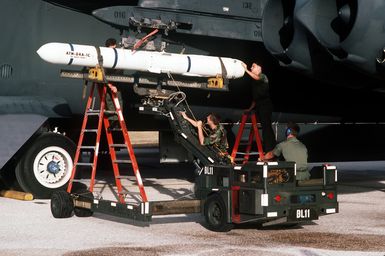 STAFF Sergeant Richard Pulaski, left, AIRMAN Christian Canada, AIRMAN Vincent Giasco and Sergeant William Reid mount an AIM-84A Harpoon missile on the wings pylon of a 60th Bombardment Squadron B-52G Stratofortress aircraft in preparation for a training exercise