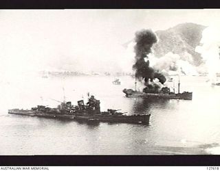 SIMPSON HARBOUR, NEW GUINEA. 1943-11-02. ENEMY (JAPANESE) LIGHT CRUISER BEWILDERED BY AN AIR ATTACK MAKES NO ATTEMPT TO ENGAGE RAAF BOMBERS AND COMES TO A STANDSTILL. OTHER SHIPS ARE BURNING IN THE ..