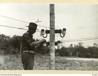 LAE, NEW GUINEA. 1944-04-03. WX8229 LIEUTENANT J.A. PRESCOTT (1). 19TH LINES OF COMMUNICATION SIGNALS, CHECKING A SUBMARINE AND JUNGLE CABLE ON THE NORTH SIDE OF THE MARKHAM RIVER AT CUTOVER POINT