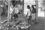 Ambaiat: distribution of pork from pig killed for damaging garden, owner (in shirt) supervises division