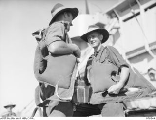 AT SEA, NEW GUINEA. 1944-10-07. N286290 PRIVATE J.E. HARRIS (1) AND V68452 PRIVATE B.G. HORNER (2) 36TH INFANTRY BATTALION CHECKING THEIR GEAR ABOARD THE DUTCH TROOPSHIP, "SWARTENHONDT" WHILE EN ..